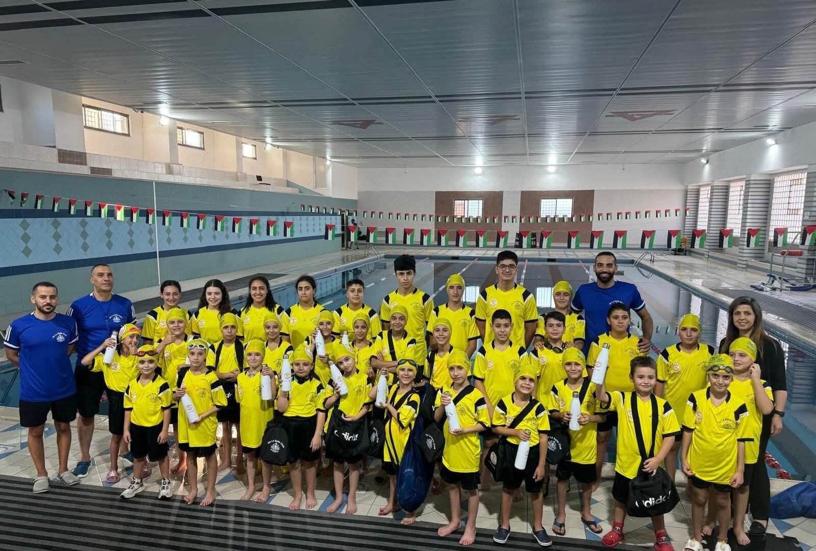 De La Salle swimming team and coaches beside the pool.