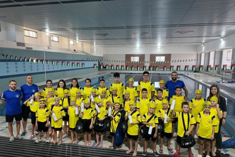 De La Salle swimming team and coaches beside the pool.